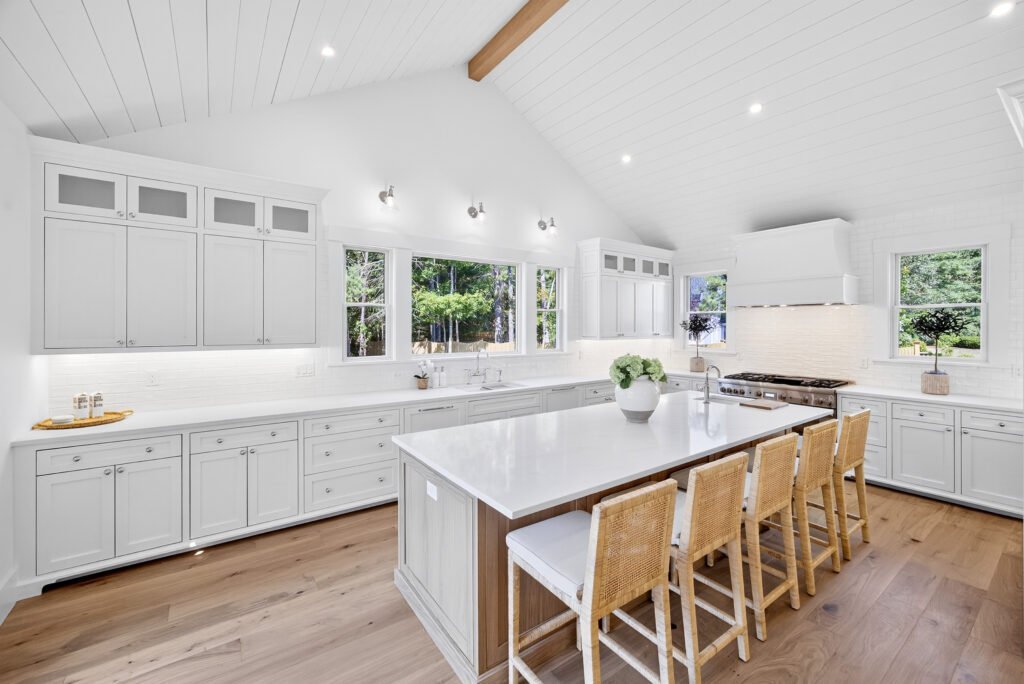 Custom white kitchen with oak island and vaulted shiplap ceiling