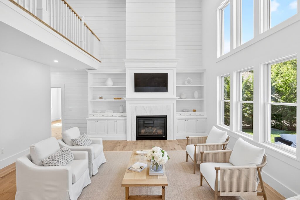 White built-in shelving and cabinetry around a marble fireplace